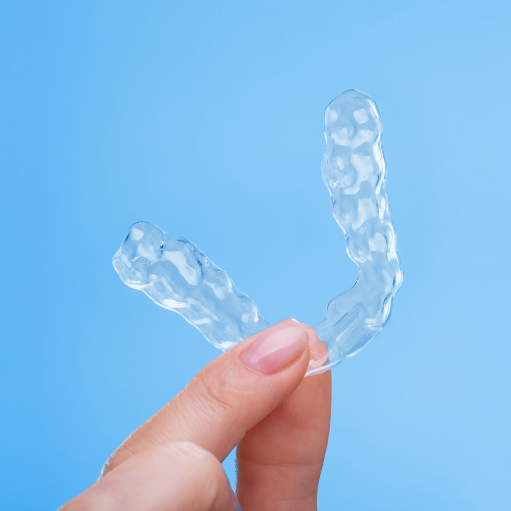 Hand holding a Clear Aligner.